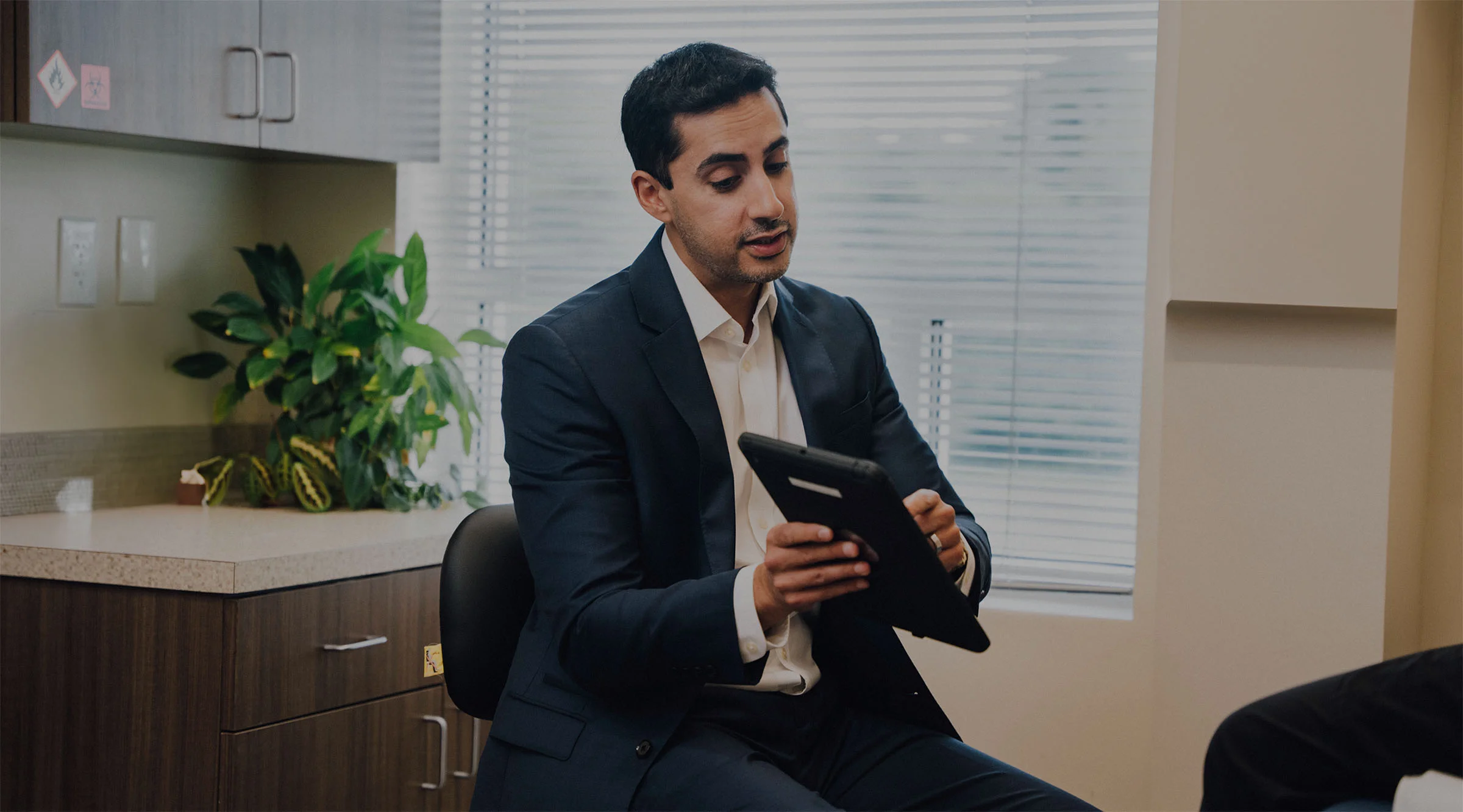 Dr. Dhir meeting with a first time patient in his office and showing the client something on the ipad. - Home, Webster, TX
