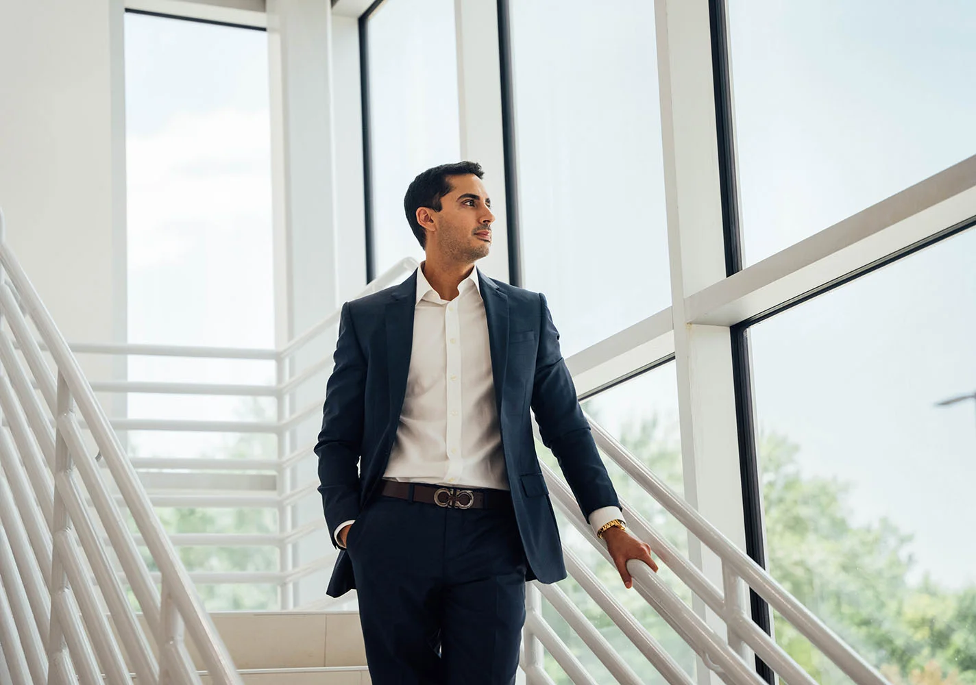 Dr. Robert Dhir looking out the window while stopped on the stairs. - Dr. Robert Dhir in Webster, TX