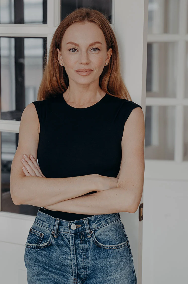 Woman in black top and denim jeans standing with folded arms. - Womens Health and Female Urology First Step in Webster, TX